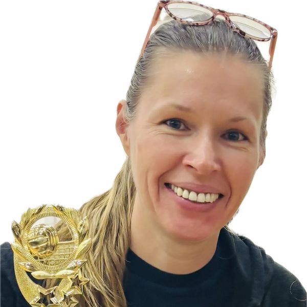 Smiling woman holding a volleyball trophy.