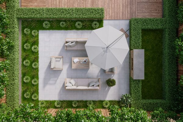 Aerial view of a modern landscaped patio with seating, umbrella, and green garden borders.