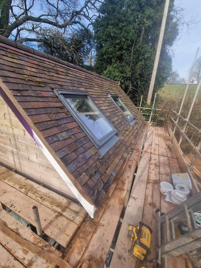 Newly installed roof windows on a tiled sloped roof with construction scaffolding Herefordshire