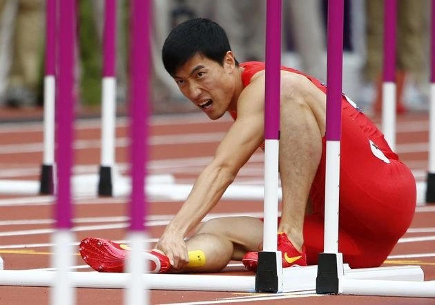 China's Liu Xiang holds his leg after suffering an injury in his men's 110m hurdles round 1 heat at the London 2012 Olympic Games at the Olympic Stadium August 7, 2012. REUTERS/Kai Pfaffenbach (BRITAIN  - Tags: OLYMPICS SPORT ATHLETICS)