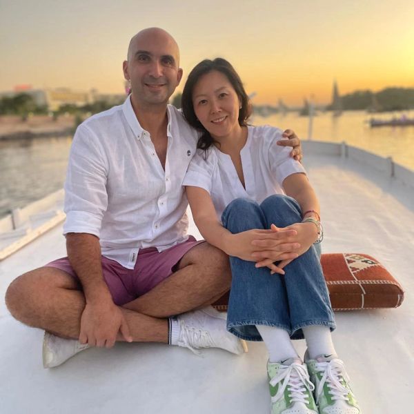 Couple sitting on a boat during sunset, smiling warmly.