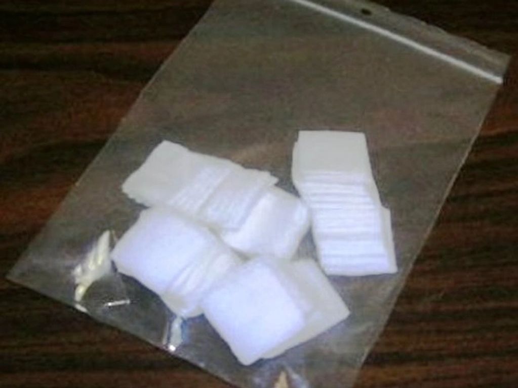 Clear bag with white folded cloth pieces on a wooden surface.
