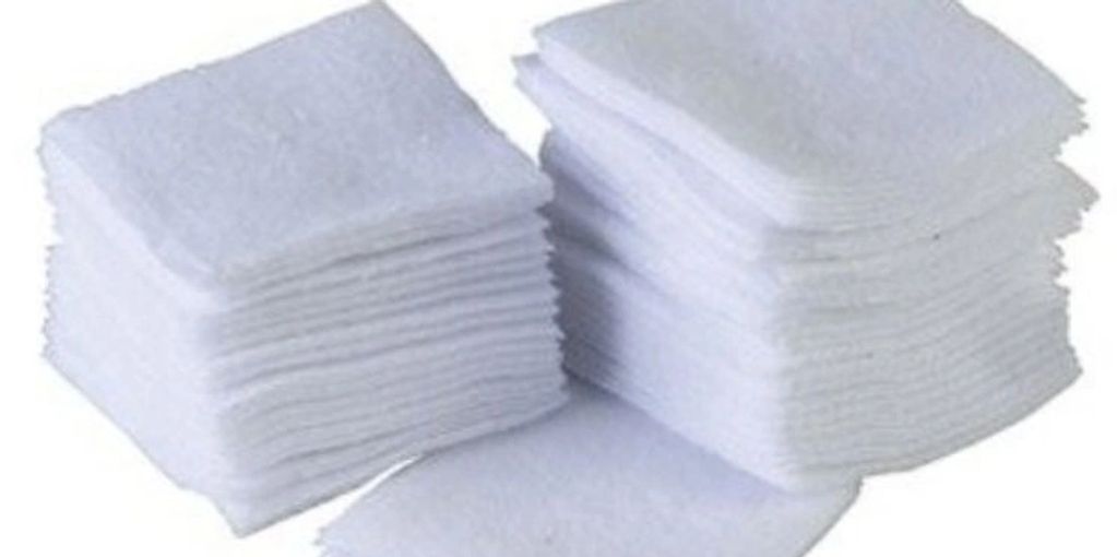 Two stacks of white folded cloths or wipes.
