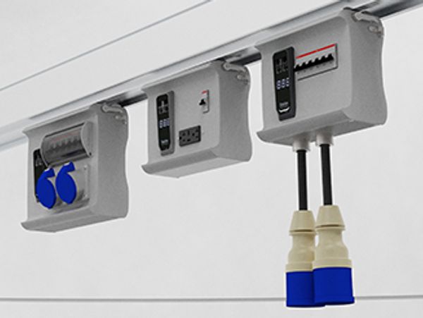 Three electrical control boxes mounted under a surface with cables and switches.