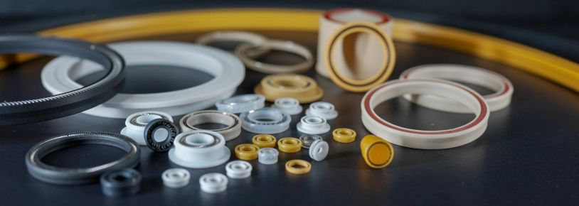 Various mechanical seals and rings on a dark surface.