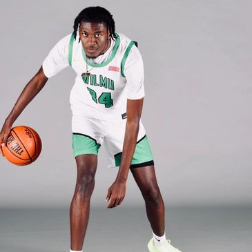 Basketball player dribbling the ball in a studio.