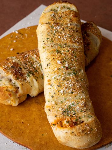Two stromboli arranged together on a plate with grated cheese on top