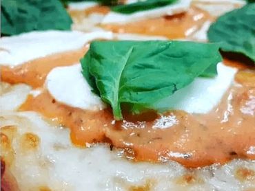 Delicious pizza featuring layer of tomato sauce and gooey cheese, resting on a perfectly baked crust