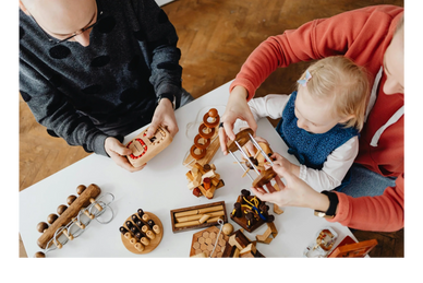 Family playing with wooden puzzles at a white table.