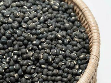 bold black urad beans in wooden basket , black matpe