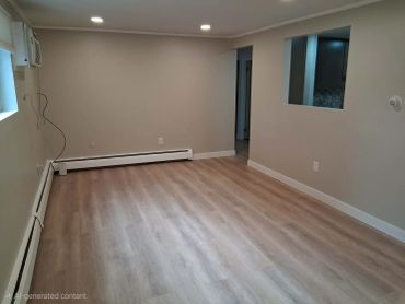 Empty room with wood flooring and recessed lighting.