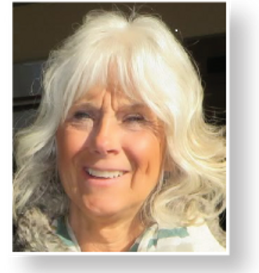 Smiling older woman with white hair in natural light.