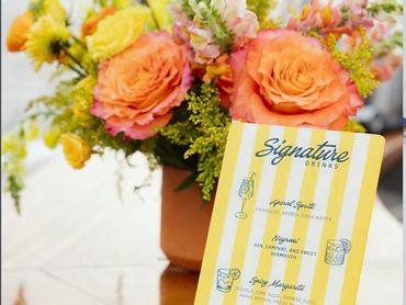 Bright floral arrangement with a drink menu.