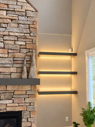 Retouched project photograph of concealed lighting above and below floating shelves.