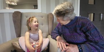 Young child and Care home resident chatting