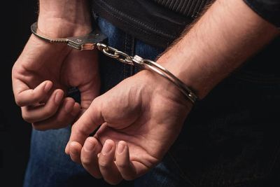 Person in handcuffs with hands behind back.