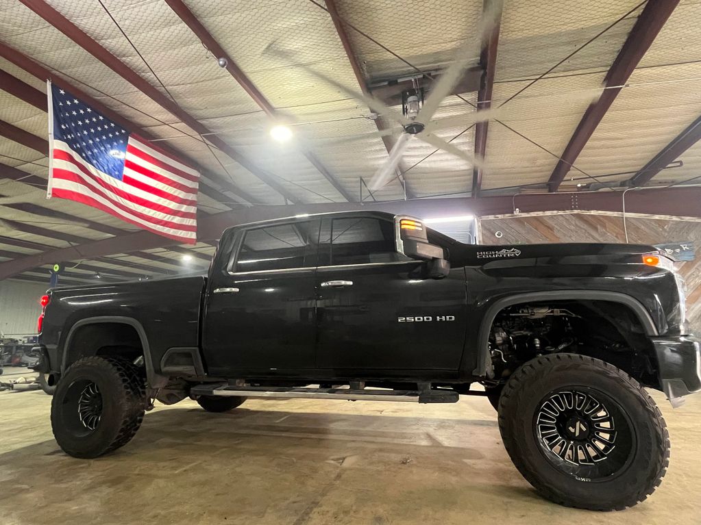 Black lifted 2500 HD pickup truck inside a garage with an American flag.