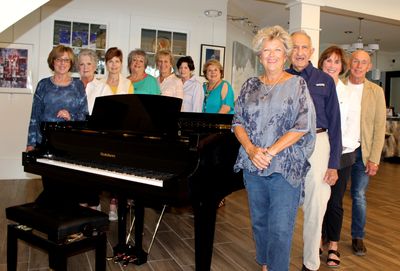 Board members with the new grand piano at the art center.