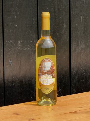 A bottle of white wine labeled "Repos de Siffleur" sits on a wooden table.