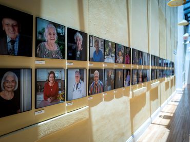 Photo exhibition of elders on yellow wall