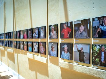 Photo exhibition of elders on yellow wall