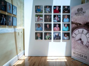 Photo exhibition pf elders on white wall