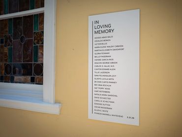 In loving memory signage on yellow wall