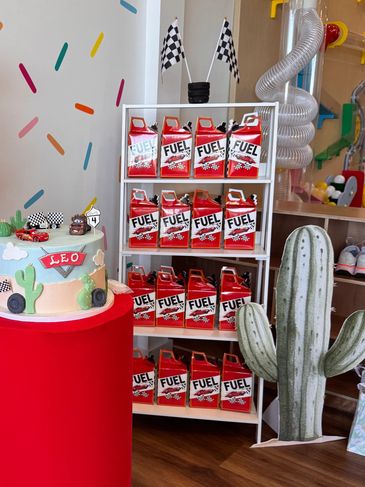 A racing-themed birthday cake and decorations with a traffic light and snack display.