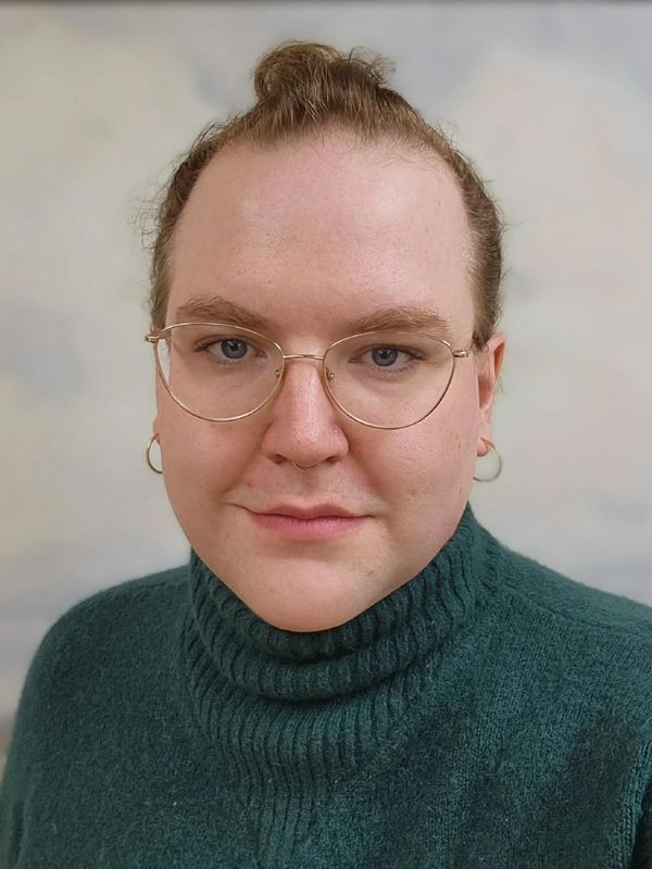 Person with glasses wearing a green turtleneck sweater.