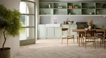 Bright modern kitchen with mint green cabinets and wooden furniture. Recycled porcelain tile floor