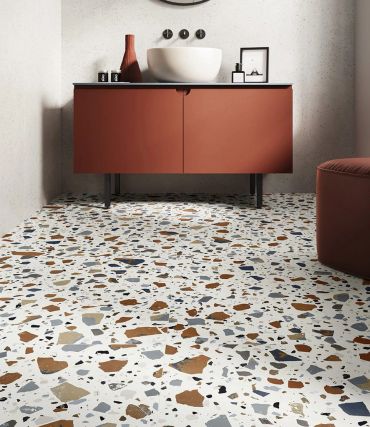 Modern bathroom with terrazzo effect porcelain floor and rust-colored vanity.