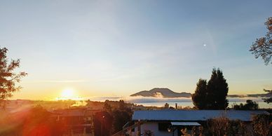 Sunrise over a mountain with mist and a peaceful backyard scene.