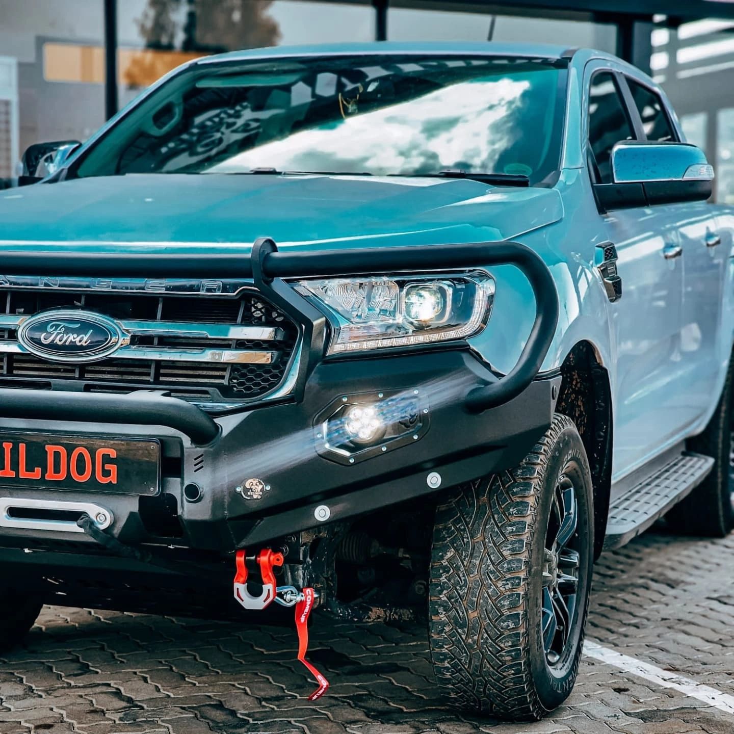 Close-up of a blue Ford Ranger with off-road modifications and BULLDOG license plate.