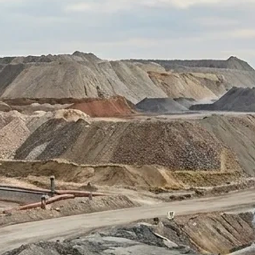 Large piles of sand and gravel at a mining or quarry site.