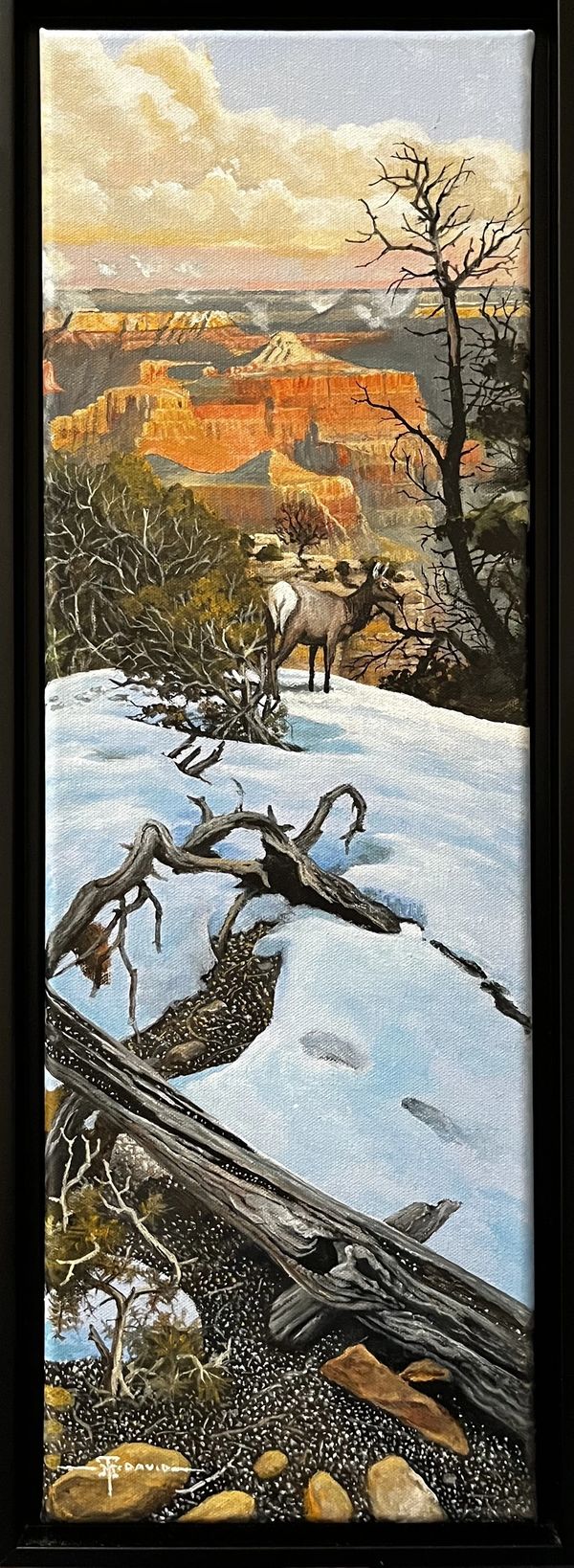 Painting of a deer on snow near a canyon at sunset.