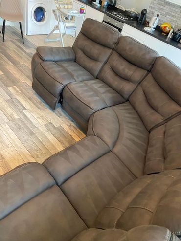 Brown sectional sofa with a reclining seat in a modern kitchen space.