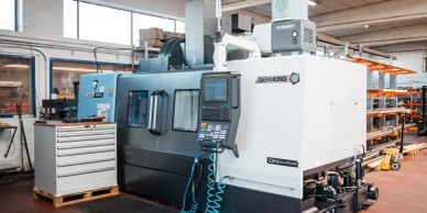 A CNC milling machine in an industrial workshop with organized storage.