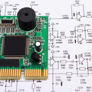 Circuit board placed on electrical schematic diagram.