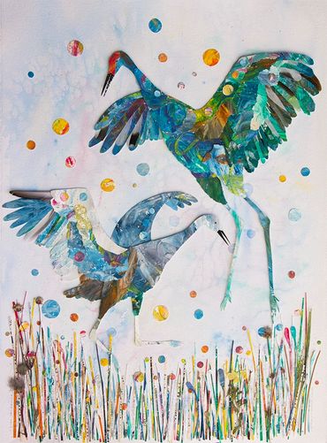 Two beautiful and colorful sandhill cranes dancing in the grass.