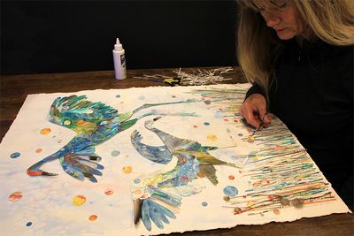 Artist Shirley Robinett creating her representation of dancing sandhill cranes.