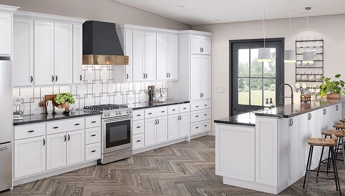 White shaker cabinets and herringbone porcelain tile with decorative backsplash.