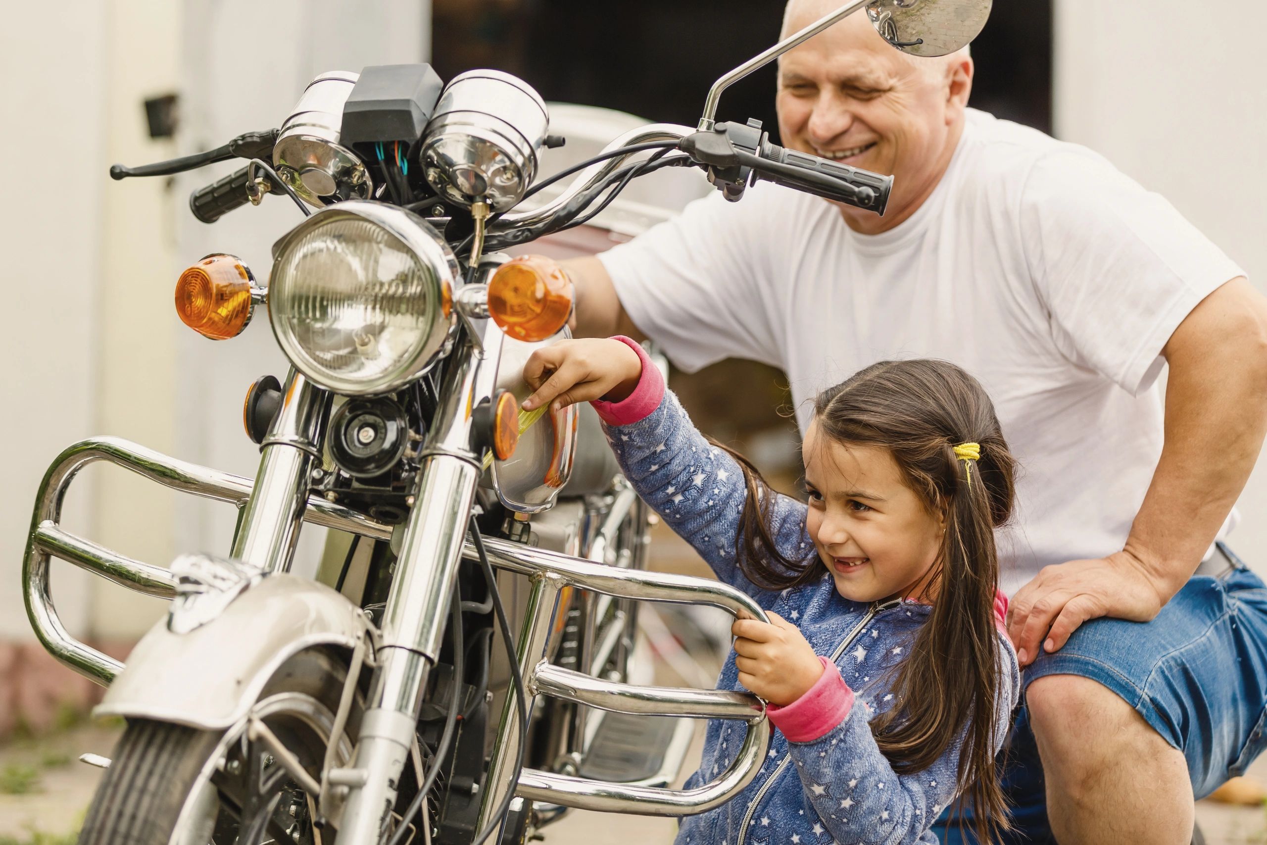 youn girl and grandfather cleaning is motorcycle