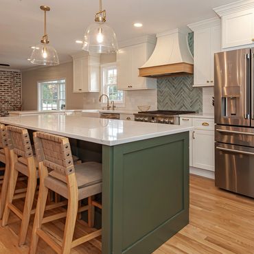Modern kitchen with green island and wood accents.