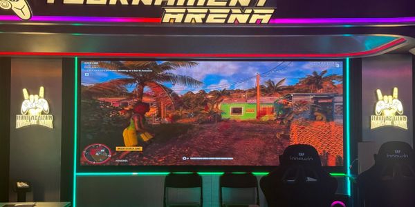 Large screen gaming setup in a neon-lit tournament arena.