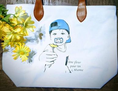 un petit garçon offre une fleur sur un sac a main