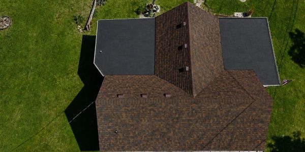 Aerial view of a house roof with two different roofing materials.