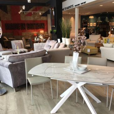 Modern furniture display in a stylish showroom with a marble table and cozy sofas.