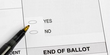 Close-up of a ballot paper with yes and no options and a pen.