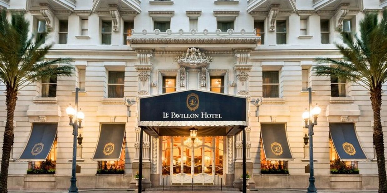 Elegant entrance of Le Pavillon Hotel with classic architectural details.