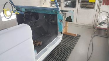Partially restored classic car interior in a workshop.
